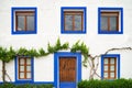 Whitewashed house facade with blue windows Royalty Free Stock Photo