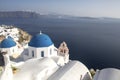 Whitewashed houses and blue dome church by the Aegean sea, Santoriniin Oia, Santorini, Greece. Famous blue domes in Oia village,