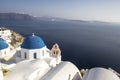 Whitewashed houses and blue dome church by the Aegean sea, Santoriniin Oia, Santorini, Greece. Famous blue domes in Oia village,