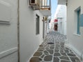 Whitewashed houses empty cobblestone alley at Naousa village, Paros island, Greece Royalty Free Stock Photo