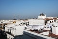 Whitewashed houses on white aerial view of terraces, roofs, clothes hanging with blue sky background