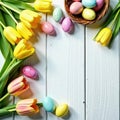 Whitewashed table, colorful eggs, yellow tulips, wicker basket, spring greenery , basket, Easter Royalty Free Stock Photo