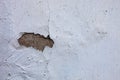 Whitewashed wall with the hole in the cracked plaster