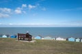 A senior lady sits on a bench looking out to sea in Tankerton, Whtistable. She has a dog with her. Royalty Free Stock Photo