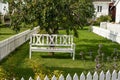 Whiyte park bench under an apple tree in a garden.. Royalty Free Stock Photo