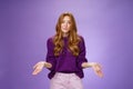 Who cares chill I not know. Portrait of clueless and unbothered cute redhead female in purple sweater smirking in sorry