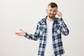 Who cares about rules. Portrait of attractive confident caucasian guy with beard in plaid shirt, taking off glasses and