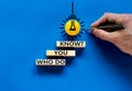 Who do you know symbol. Businessman hand, light bulb icon. Wooden blocks with words `who do you know`. Beautiful blue background