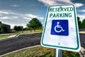 Handicap Reserved Parking Sign in Lot Select Focus - Wheelchair Accessible - Blue Skies, Grass, Trees Royalty Free Stock Photo