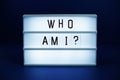 Who am I letterboard text on LED Lightbox on blue background