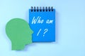 Who am I question in blue notebook. Self awareness and knowledge concept. Royalty Free Stock Photo