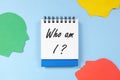 Who am I question in blue notebook. Self awareness and knowledge concept. Royalty Free Stock Photo