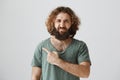 Who left rotten tomato in fridge, smells terrible. Portrait of displeasure easter curly-haired male with beard pointing Royalty Free Stock Photo