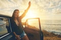 Who loves the open road. Cropped portrait of a young woman on a road trip to the beach at sunset.