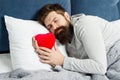 Who is my valentine. bearded hipster sleep in bed. Heart filled with love. man feel romance. holidays and surprise