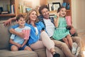 Who needs a cinema when theres a family sized sofa. a happy family watching movies on the sofa at home. Royalty Free Stock Photo