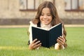 Who needs rest when theres another book to be read. Adorable small child read book on green grass. Cute little girl Royalty Free Stock Photo