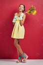 Who said chores werent fun. Studio shot of a young woman holding a feather duster against a red background.