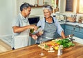 Who said dinner prep has to be a chore. a happy mature couple drinking wine while cooking a meal together at home. Royalty Free Stock Photo