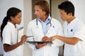 Who treated this diagnosis. Group of doctors having a discussion while holding an digital tablet. Royalty Free Stock Photo