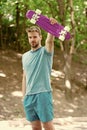 Who want to learn extreme trick. Guy carries penny board ready to ride. Man serious face carries penny board park nature Royalty Free Stock Photo