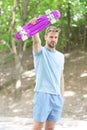 Who want to learn extreme trick. Guy carries penny board ready to ride. Man serious face carries penny board park nature Royalty Free Stock Photo