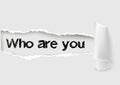 Who are you question written under the curled piece of White torn paper Royalty Free Stock Photo