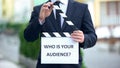 Who is your audience question on clapperboard in hands of male celebrity, pr