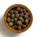 Whole allspice in dark wood bowl isolated on white. Royalty Free Stock Photo