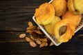 Whole apricots and halves in a basket, on a wooden table with broken apricot pits. Top view. Flat lay. Food concept