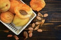 Whole apricots and halves in a basket, on a wooden table with broken apricot pits. Top view. Flat lay.