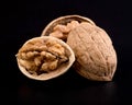 A whole beautiful walnut kernel in half a walnut shell and half a walnut kernel in a beautiful textured shell Royalty Free Stock Photo