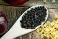 Whole black pepper on wooden spoon, pasta and onion Royalty Free Stock Photo