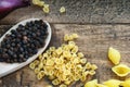 Whole black pepper on wooden spoon and pasta Royalty Free Stock Photo