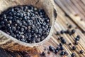 Whole black Peppercorns on old wooden table. Close up, selective focus. Royalty Free Stock Photo