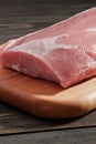 Whole boneless pork loin without fat close-up. Pork tenderloin on a cutting board on a dark background Royalty Free Stock Photo