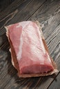 Whole boneless pork loin without fat. Pork tenderloin on paper on a dark background Royalty Free Stock Photo