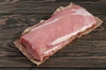 Whole boneless pork loin without fat. Pork tenderloin on paper on a dark background Royalty Free Stock Photo