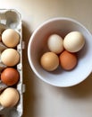 Whole brown eggs in a package and bowl