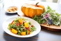 whole butternut squash beside a colorful roasted squash salad