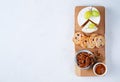 Whole Camembert cheese served with grapes, chutney, cranberry crackers, pecans nuts over wooden kitchen table, light marble