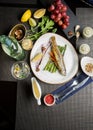 whole carcass of sea trout on the grill. Fried red fish with vegetables and sauce. Close-up. Concept - food  delicacies Royalty Free Stock Photo