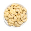 Whole cashews in bowl isolated on white background. Top view