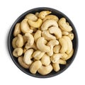 Whole cashews in dark bowl isolated on white background. Top view