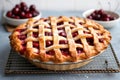 a whole cherry pie with a lattice crust on a baking rack