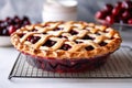 a whole cherry pie with a lattice crust on a baking rack