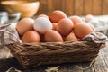 Whole chicken eggs in basket on wooden table Royalty Free Stock Photo