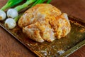 Whole chicken seasoned uncooked in baking tray with chopped