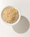 Whole Chinese Rice seed. Grains in a bowl. Shadow over white ta Royalty Free Stock Photo