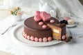 Whole chocolate cake and slice with chocolate frosting and pink heart decoration on the table Royalty Free Stock Photo